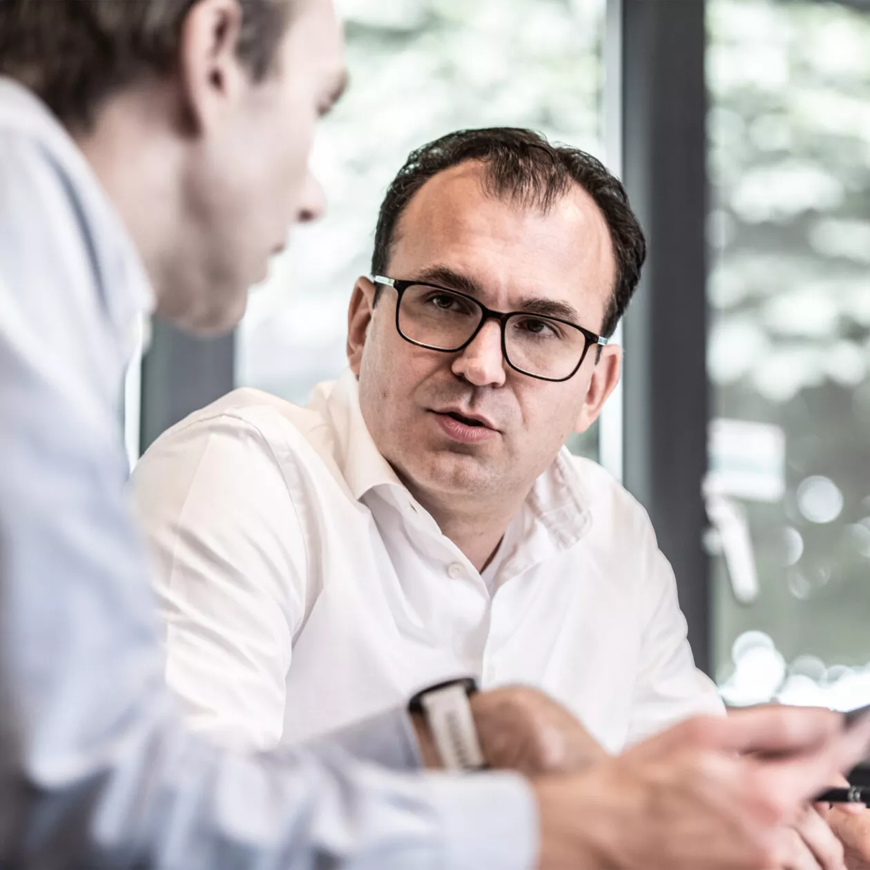Two Twentebelt employees discuss a conveyor belt at our office